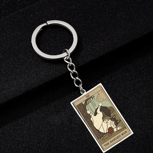 Macro detail of XII The Hanged Man cat tarot card pendant on stainless steel keychain