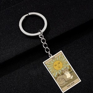 Retro Tarot The Sun card keychain with cat and sunflower on black textured surface