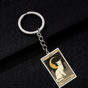 Macro shot of stainless steel Tarot keychain detail featuring The Moon cat oil painting