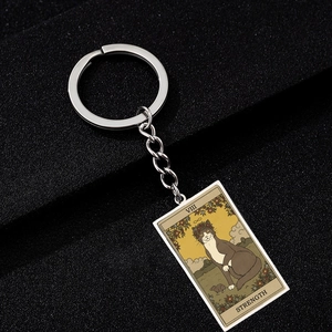 Macro shot of Strength Tarot card cat illustration on a rectangular metal keychain
