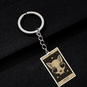 Macro shot of stainless steel keychain featuring Death tarot card with cat skull design