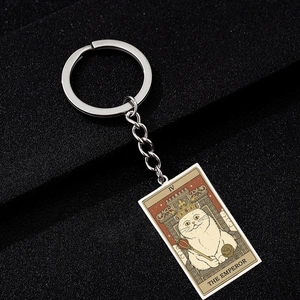 Detail of a vintage cat tarot keychain featuring The Emperor design on textured background