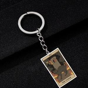 Detailed view of The Tower Tarot card keychain featuring a black cat and tower on metal