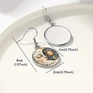 Handmade celestial drop earrings featuring sun and moon glass pendants on a white tray