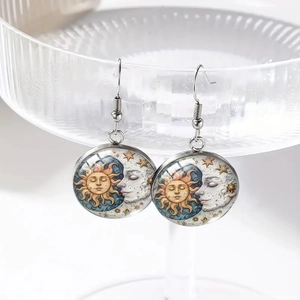 Handmade celestial glass earrings with sun and moon celestial theme on silver ear hooks