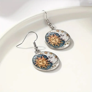 Detailed shot of celestial sun and moon glass pendants on silver-colored ear hooks