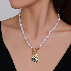 Detail of vintage pearl necklace featuring hummingbird pendant and gold OT toggle clasp