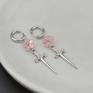 Détails des boucles d'oreilles épée gothique avec fleur de cerisier rose sur céramique
