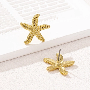 Boucles d'oreilles puces étoile de mer dorées avec texture sur décor géométrique
