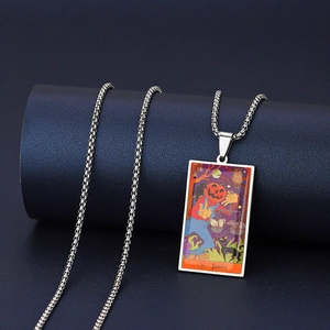 Détail du pendentif Tarot Justice avec tête de citrouille, chat noir et motif de balance