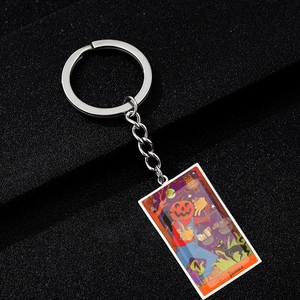 Close-up of Justice tarot card keychain with colorful Halloween pumpkin illustration