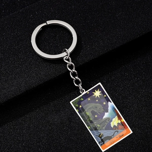 Macro detail of The Star tarot card keychain with gothic black cat and gargoyle art
