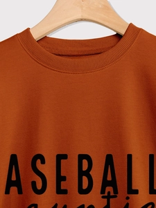 Detail of crewneck collar and baseball auntie print on orange cotton sweatshirt