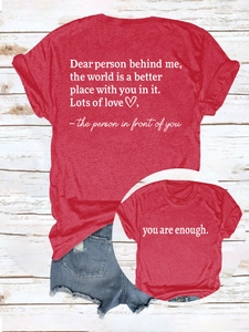 Flat lay of red cotton t-shirt with white motivational text and denim shorts