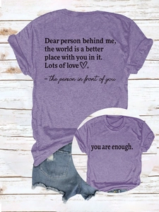 Detail of purple short sleeve t-shirt featuring double-sided motivational print on wood floor
