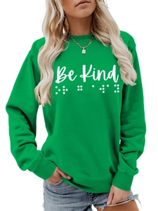 Detail of green crewneck sweatshirt with Be Kind text and Braille pattern
