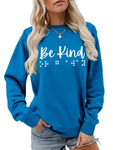 Close-up of blue crewneck sweatshirt with Be Kind text and Braille print detail