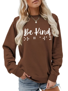 Detail of Be Kind text and braille pattern on brown crewneck long sleeve sweatshirt