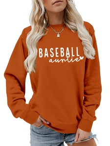 Close-up of bright orange sweatshirt featuring white Baseball Auntie lettering and heart print