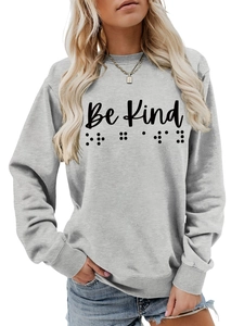 Detail of the gray crewneck sweatshirt showing the Be Kind text and braille dots design