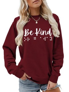Detail of Be Kind text and Braille print on a burgundy crewneck sweatshirt for women