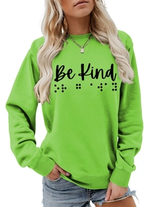 Detail of lime green sweatshirt featuring Be Kind text and braille dots pattern