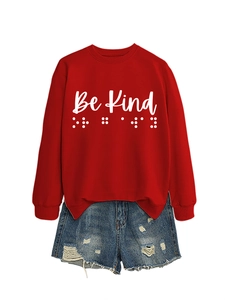 Detail of red crewneck sweatshirt with Be Kind text and matching distressed denim shorts