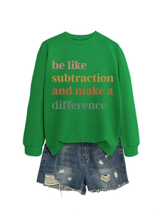 Flat lay di una felpa verde con scritte colorate e pantaloncini di jeans strappati