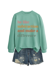 Dettaglio della felpa verde menta con slogan colorato e pantaloncini di jeans strappati