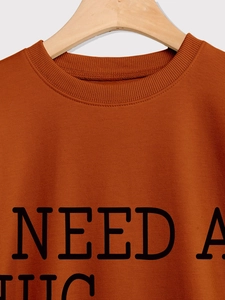 Detail of the rust-red crewneck sweatshirt with high-quality ribbed collar and black lettering