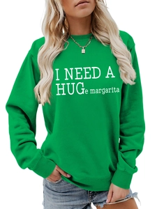Close-up of I NEED A HUGe margarita text print on a green crewneck sweatshirt