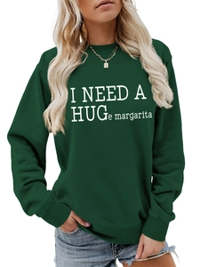 Close-up of ribbed cuffs and white letter print on a dark green crewneck sweatshirt