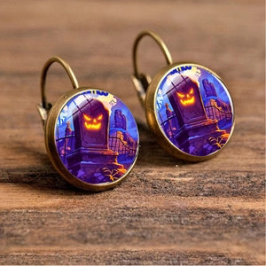 Close-up of Halloween drop earrings featuring pumpkin head and graveyard patterns
