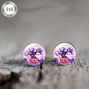 Macro shot of Halloween ghost and pumpkin stud earrings on a rustic wood surface