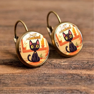 Detailed close-up of bronze-finish Halloween earrings with black cat and text on wood