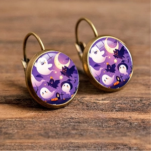 Detailed view of Halloween earrings with ghost and pumpkin charms on a wooden background