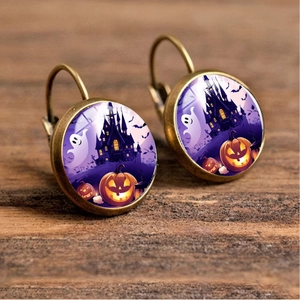 Detail of vintage bronze Halloween earrings with pumpkin, ghost, and castle patterns