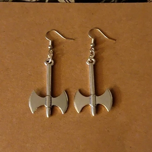 Detail shot of silver gothic labrys battle axe drop earrings on a card display