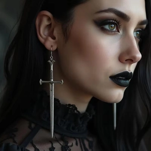 Gothic silver sword drop earrings featuring intricate medieval hilt details on a model