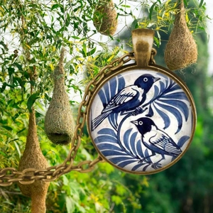 Vintage bronze necklace with a glass bird pendant featuring blue and white bird artwork