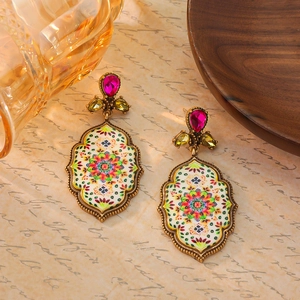 Close-up of vintage bohemian mandala earrings with colorful rhinestones and retro patterns
