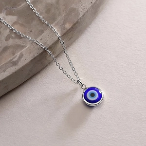 Türkische Evil Eye Glashalskette mit Silberkette im 45-Grad-Winkel auf Steinhintergrund