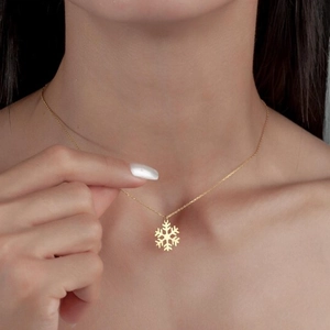 Collier avec pendentif flocon de neige doré évidé porté pour un look festif
