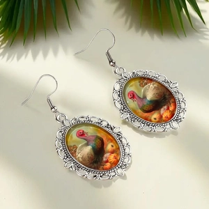 Detailed view of silver scalloped earrings with Thanksgiving turkey and pumpkin patterns