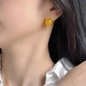Detailansicht der 10mm gelben Achat-Ohrstecker am Modell für elegante Alltagslooks