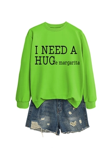 Detail of neon green sweatshirt with I NEED A HUGE margarita text and ripped denim shorts