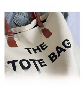 Close-up of canvas tote bag featuring premium leather handles and metal hardware detail