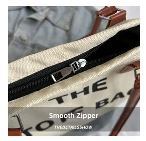 Detailed macro view of the smooth black zipper and fabric texture of the canvas tote bag