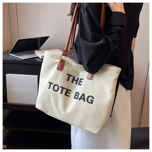 Detail view of canvas tote bag with leather handles and The Tote Bag print