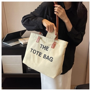 Detail showing inner capacity of the cream canvas tote bag with brown leather straps
